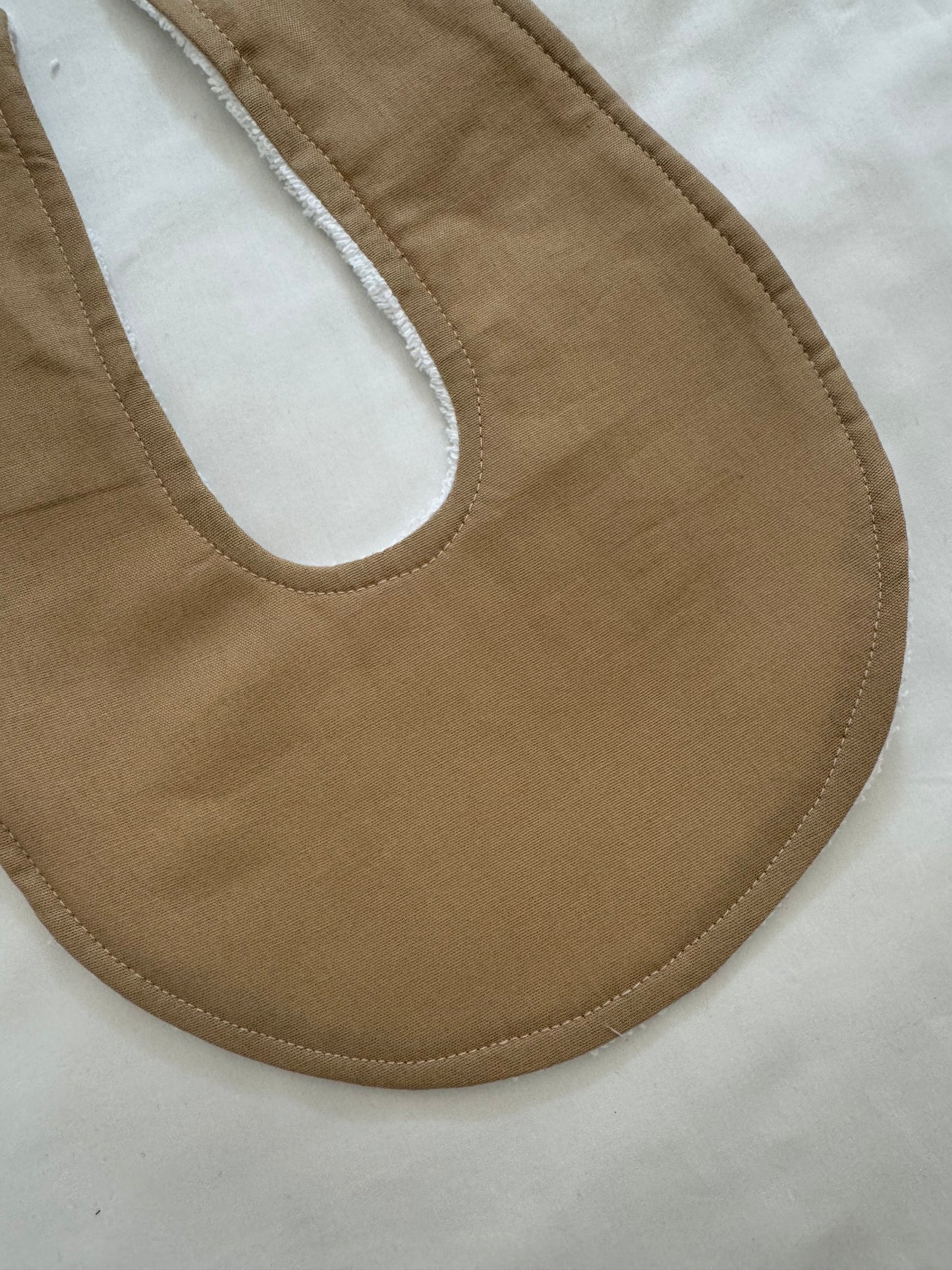 Tan round bib